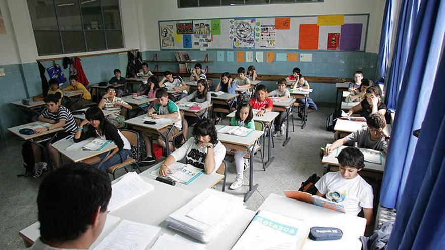 Alumnos de la ESO sentados en sus pupitres en un aula.