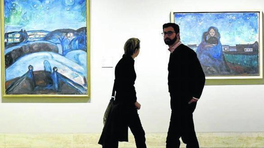 Dos personas pasan junto a las obras ‘Bajo las estrellas’ y ‘Noche’, en el Museo Thyssen en Madrid.