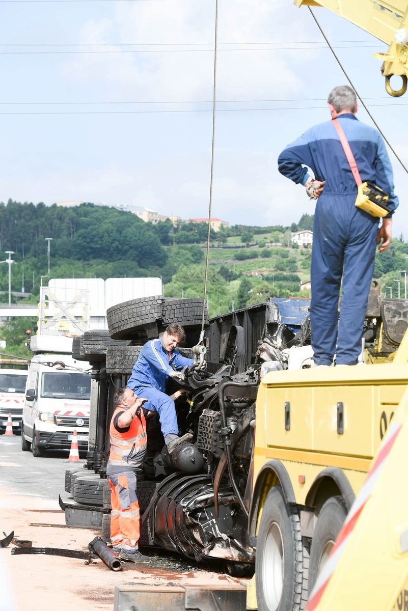 Trabajos para retirar de la calzada el camión volcado en el Txorrierri