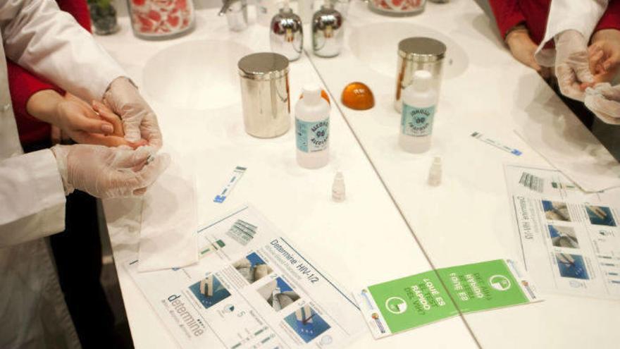 Una farmaceútica toma una muestra de sangre para realizar un test rápido del VIH.