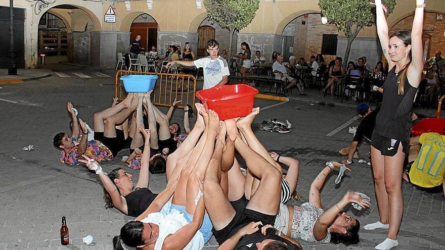 Juego de quitarse los calcetines sin que se caiga el cubo con agua. 