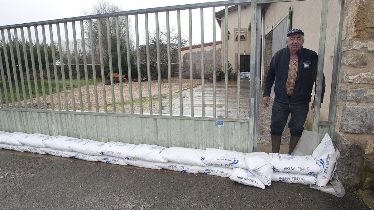 Un vecino de Arcaute protege su casa contra posibles inundaciones del río Santo Tomás.