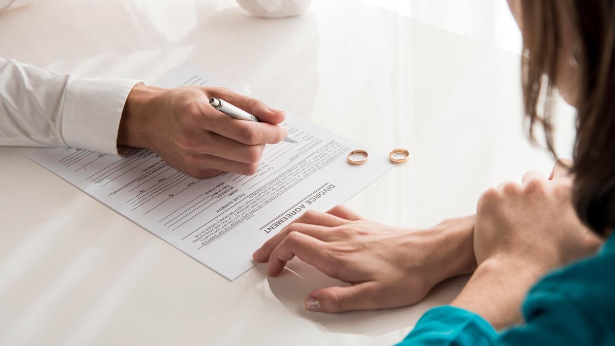 Una pareja firma el acuerdo de divorcio.