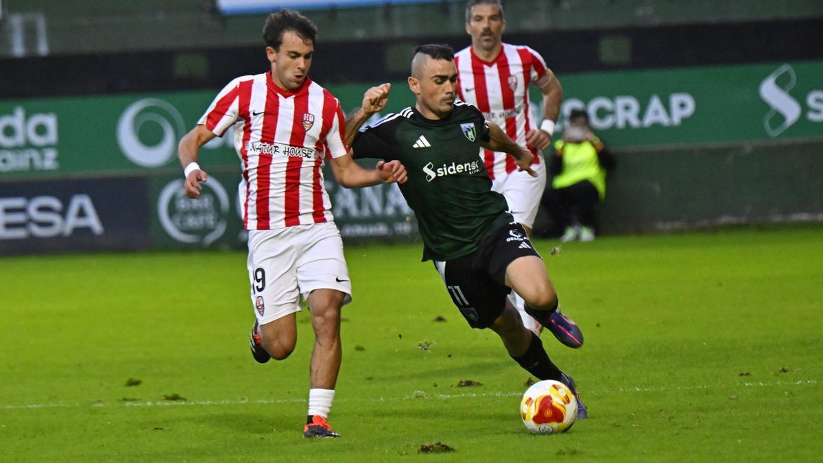 Jon Madrazo conduce el balón ante la presión de un rival.