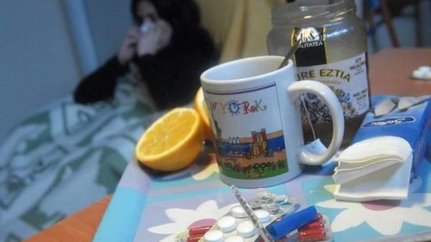 Una mujer descansa rodeada de todos los remedios &#039;de libro&#039; para combatir el resfriado