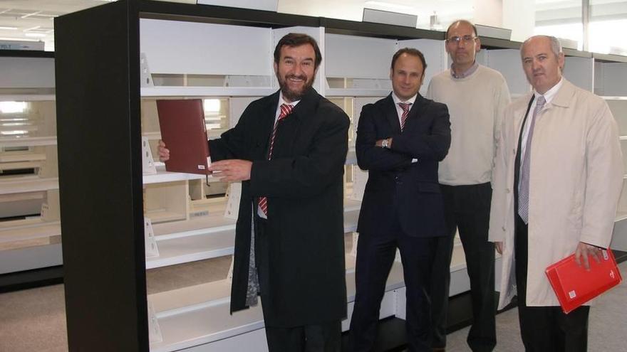 El consejero Juan Ramón Corpas, titular de Cultura, entrega el primer libro que nutrirá las estanterías del nuevo equipamiento.