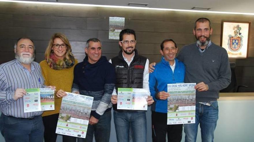 Los asistentes a la presentación posan con los carteles del cross popular.