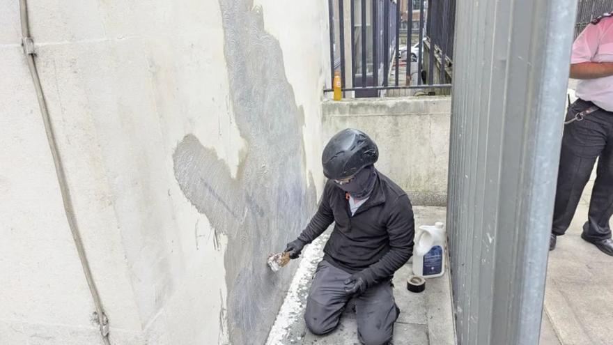 Repintando el muro para borrar el trabajo de Banksy.