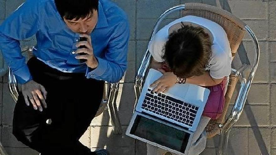 Un grupo de jóvenes, reunidos con sus ordenadores portátiles.