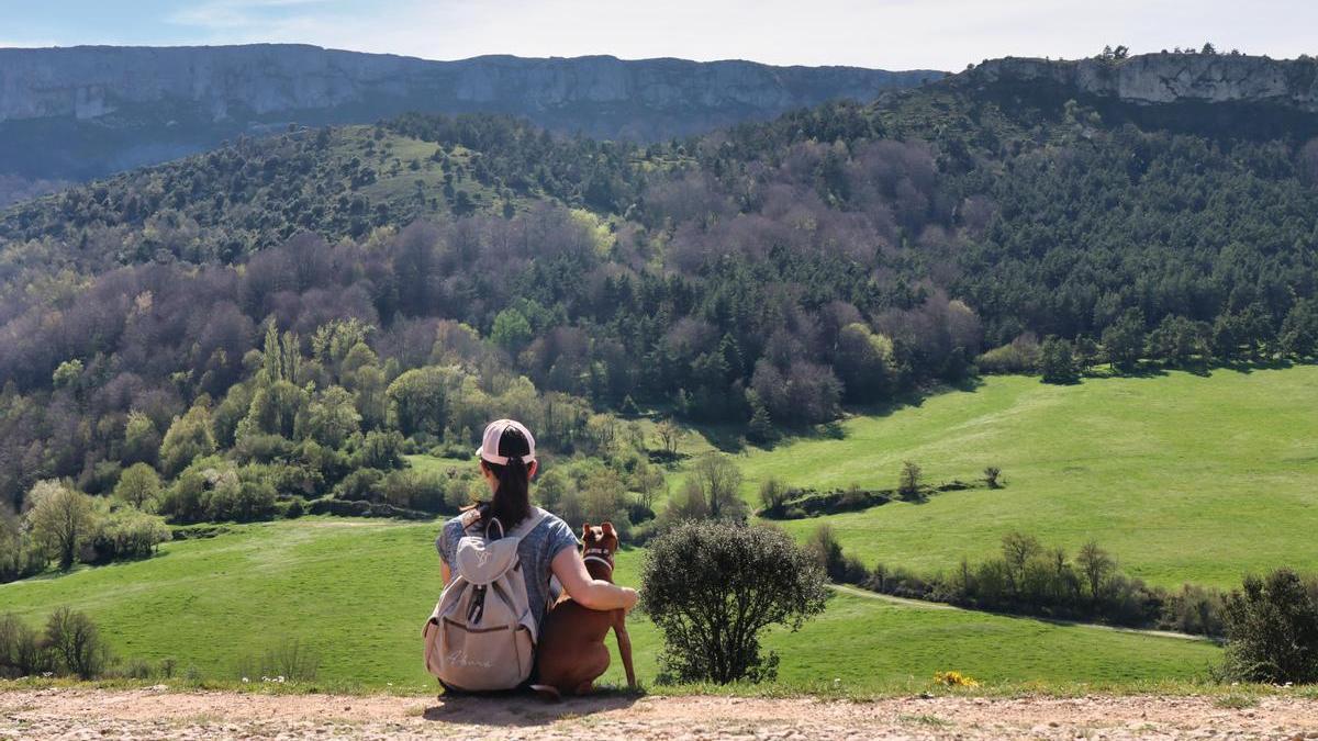 Una niña con su perro admirando el paisaje del Parque Natural de Valderejo