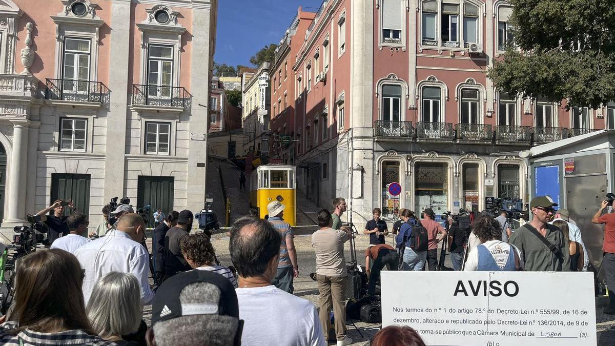 Medios de comunicación y viandantes en el lugar del funicular accidentado en Lisboa.