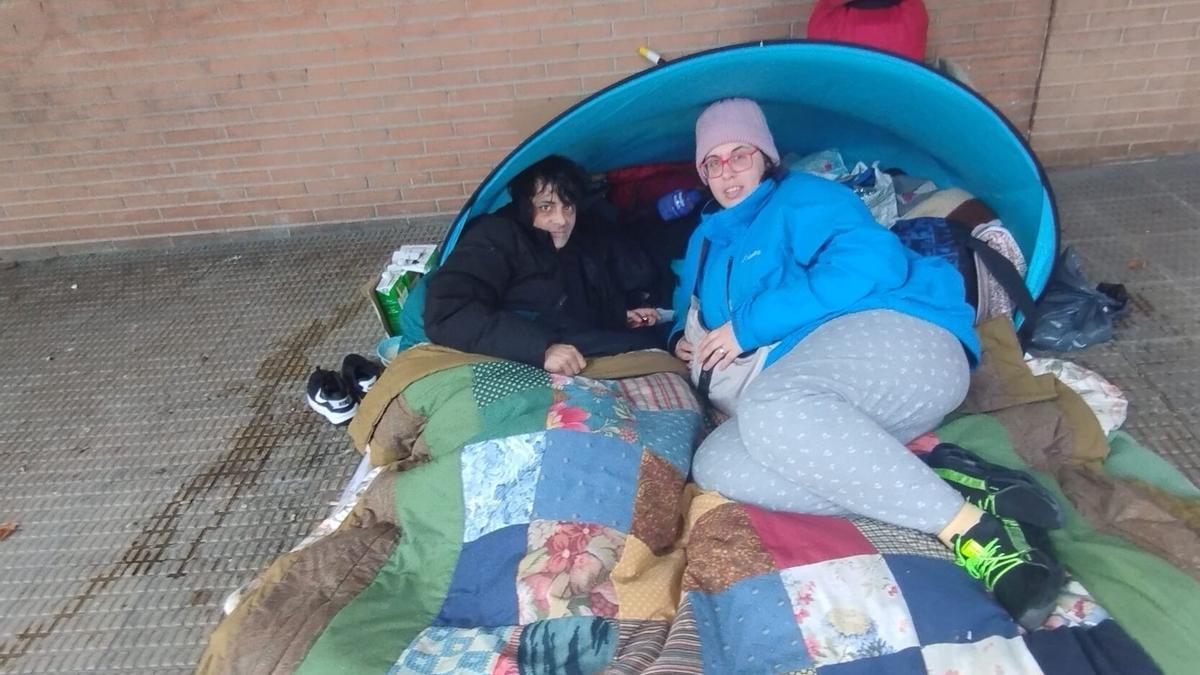 David y Silvina, en el porche donde tienen su tienda y algunas pertenencias personales.