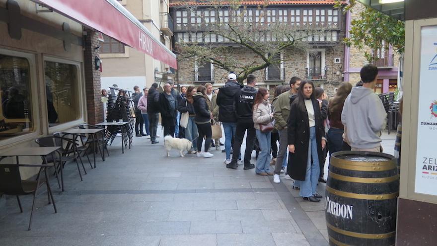 Los jóvenes hacen cola para conseguir los bonos.