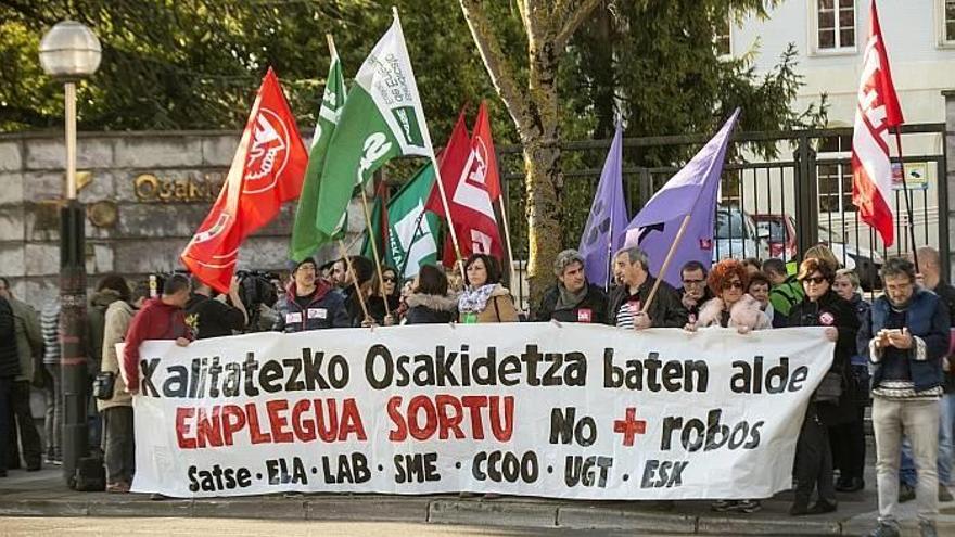 Representantes de los sindicatos Satse, ELA, LAB, SME, FFHE, CC.OO., UGT y ESK, durante la concentración que han llevado a cabo hoy frente a los Servicios Centrales de Osakidetza, en Gasteiz.