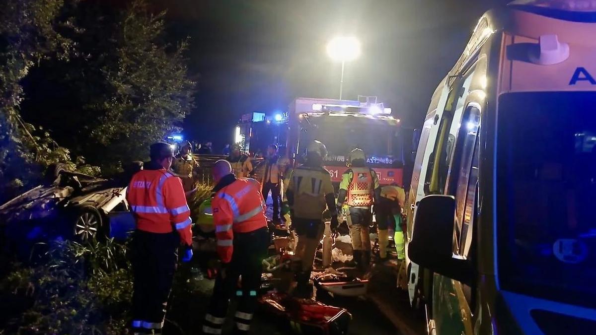 El vehículo accidentado, volcado a la izquierda de la imagen, entre los equipos de asistencia.