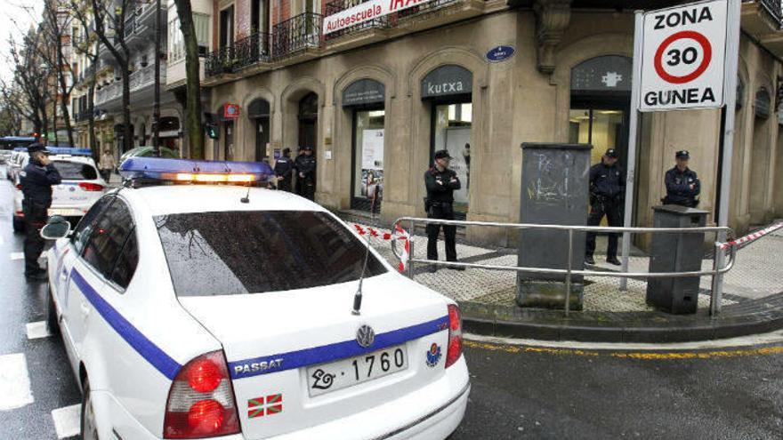 Agentes de la Ertzaintza en la sucursal de Kutxabank de Donostia en la que ha tenido lugar el atraco.