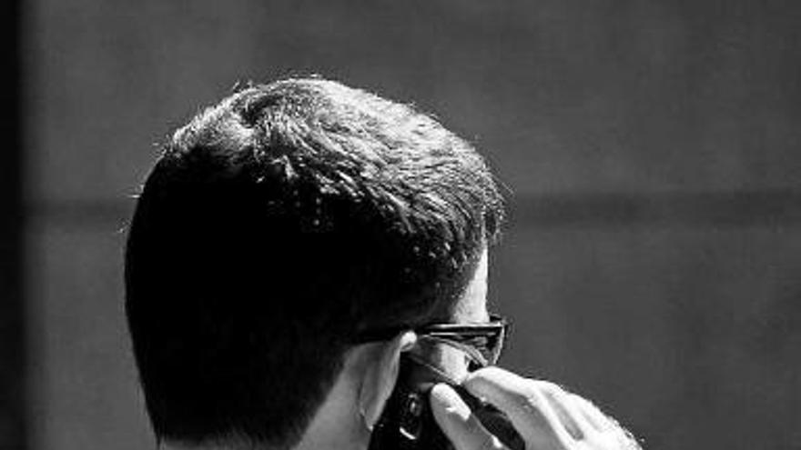 Un joven habla por teléfono móvil.