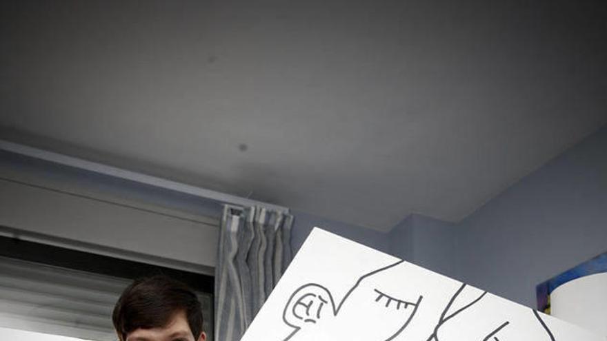 Gonzalo Bañón posa en su cuarto sujetando el cartel que presentó el año pasado al concurso del cartel de San Fermín.