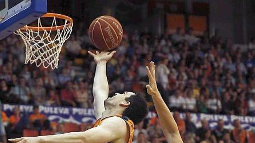 El escolta del Valencia Basket, Rafa Martínez, trata de encestar ante la oposición del escolta del Bilbao Basket, Dairis Bertans