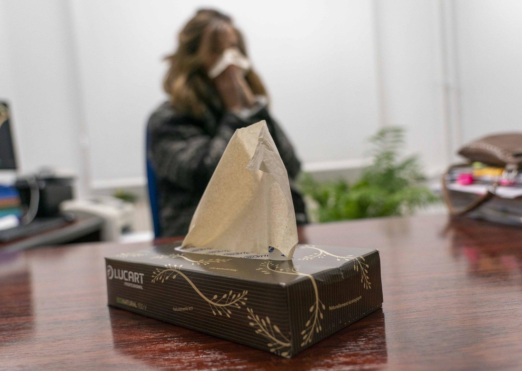 Una mujer afectada por un virus respiratorio se suena la nariz.