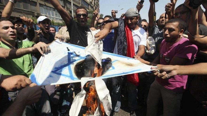 Unos manifestantes egipcios queman una bandera israelí frente a la Embajada israelí en El Cairo, Egipto.