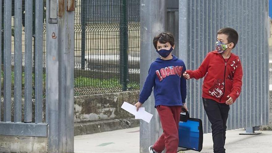 Dos niños con mascarilla en el exterior de sus centros