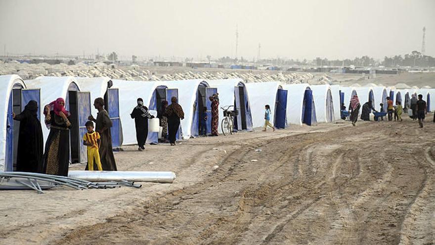 Varias personas reciben nuevas tiendas de campaña en un campo de refugiados en Faluya a 60 kilómetros al oeste de Bagdad