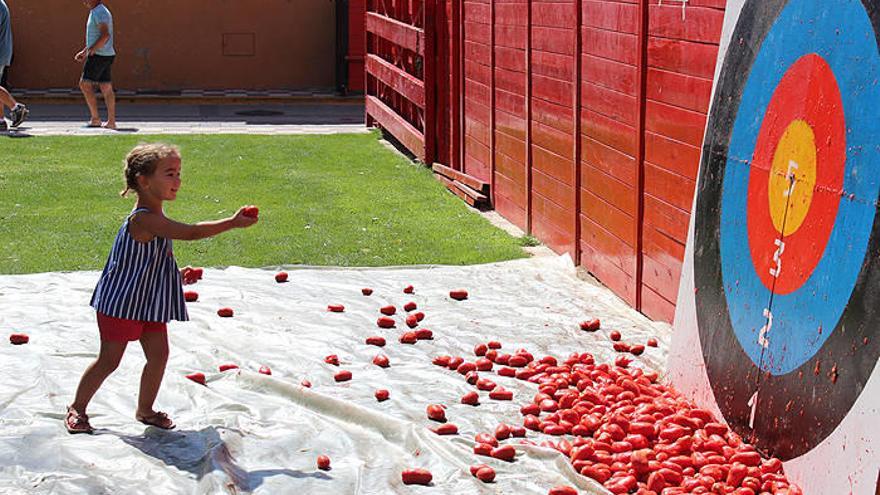 Una niña lanza un tomate a una diana gigante.