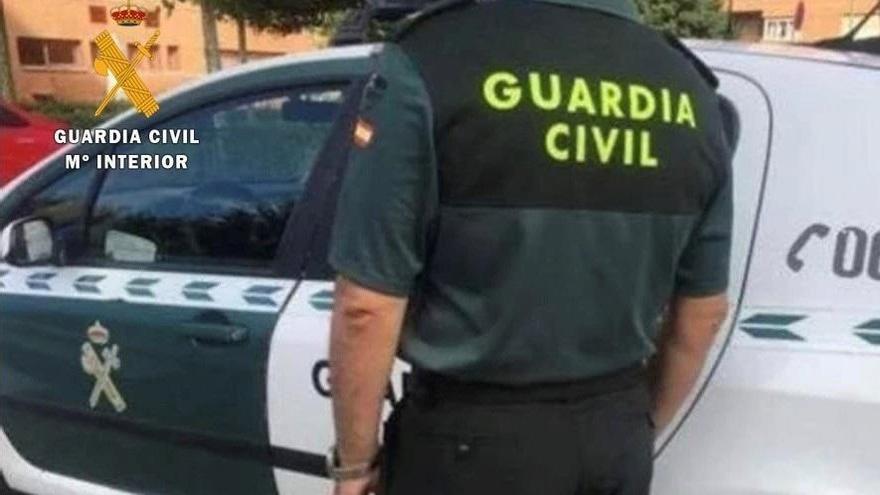 Un agente junto a su vehículo de la Guardia Civil.