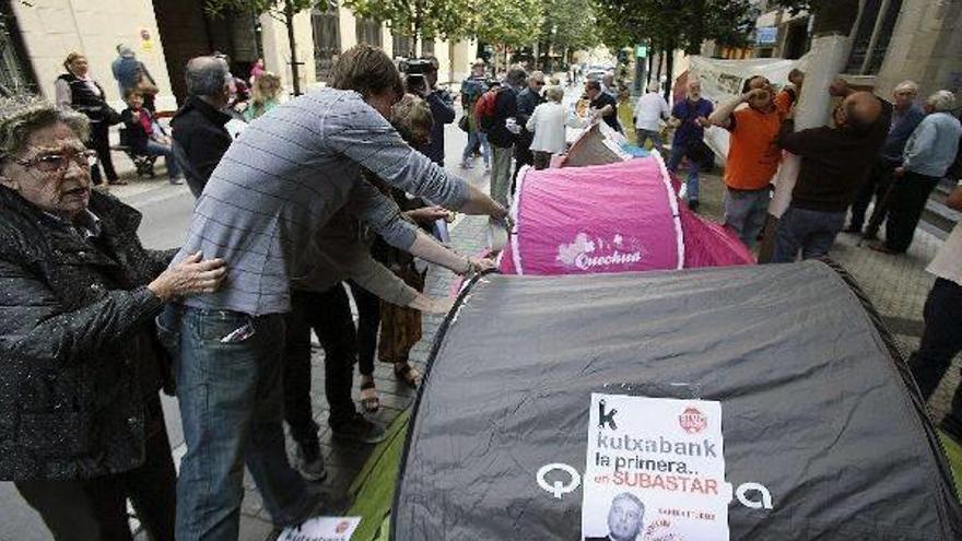 Protesta de colectivos contrarios a la “privatización” de Kutxa, ayer junto a la sede de la caja.