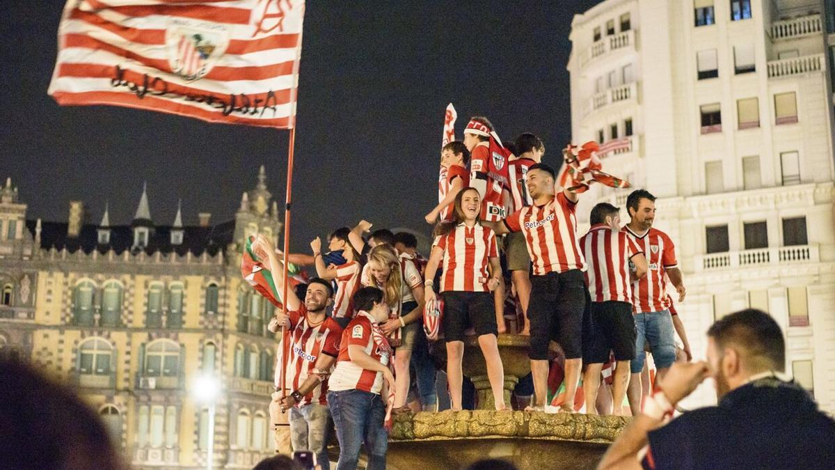 Aficionados del Athletic Club celebran en la fuente de la plaza Moyua de Bilbao