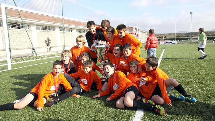 Los integrantes de Mendigoiti celebran el triunfo posando con la copa que les acredita como campeones.