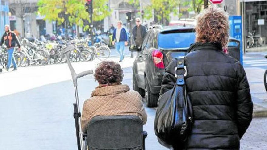 Una mujer transita por una zona peatonal con una ‘scooter’ para discapacitados.