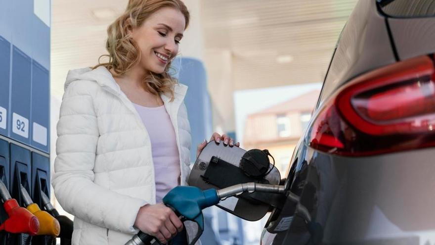 Una mujer reposta en una gasolinera.