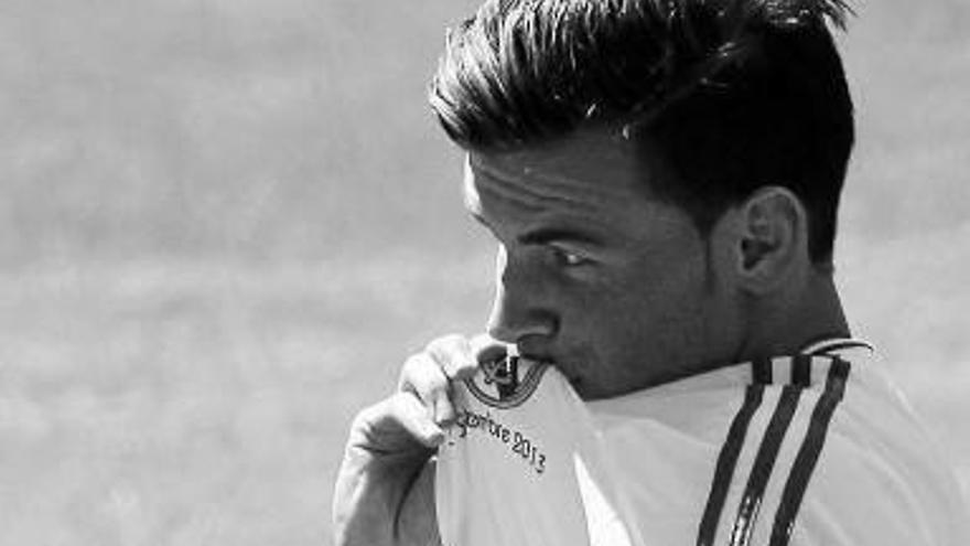 Bale besa el escudo de su nuevo club el día de su presentación.