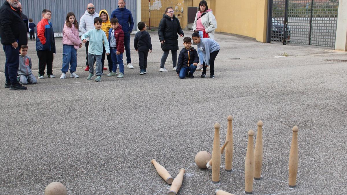 Niños y mayores jugando a los bolos.