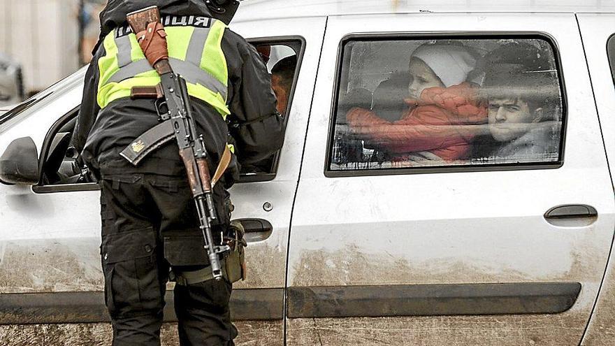 Un policía comprueba la documentación de una familia recién llegada a Zaporiyia desde Mariúpol.  Foto: Efe