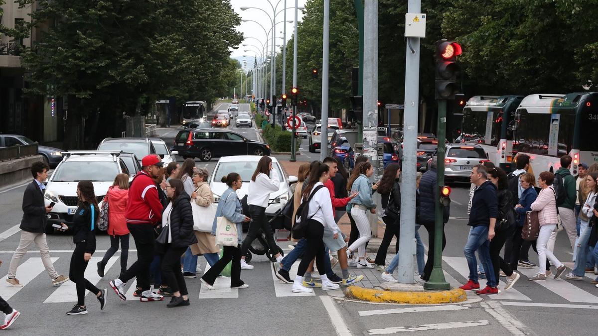 Numerosas personas cruzan un paso de peatones en el centro de Pamplona.