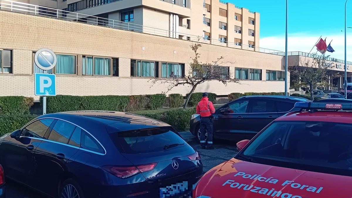 Agentes de Policía Foral multando a usuarios que aparcan en plazas para personas con discapacidad en el Reina Sofía de Tudela.