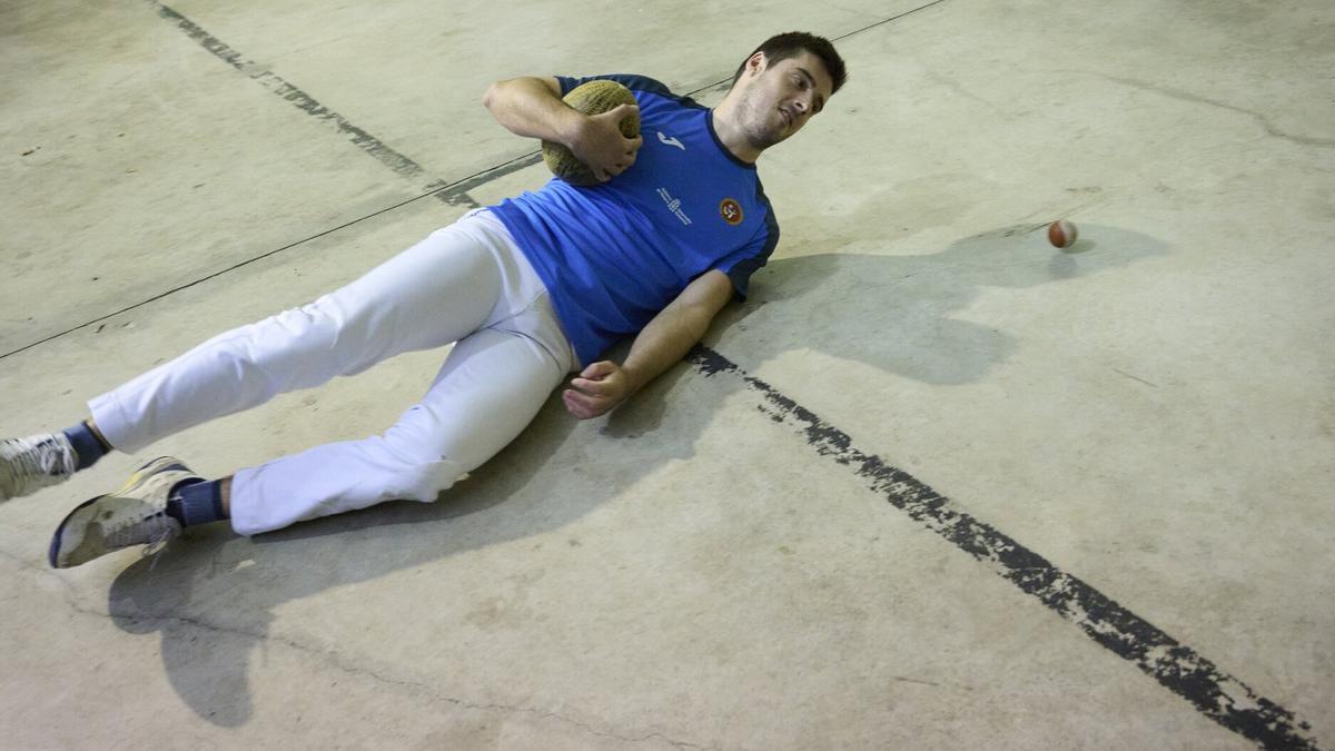 Javier Oskoz no duda en lanzarse al suelo para levantar una bola con una melón en su mano izquierda, de acuerdo a como se solía jugar años atrás en este frontón.