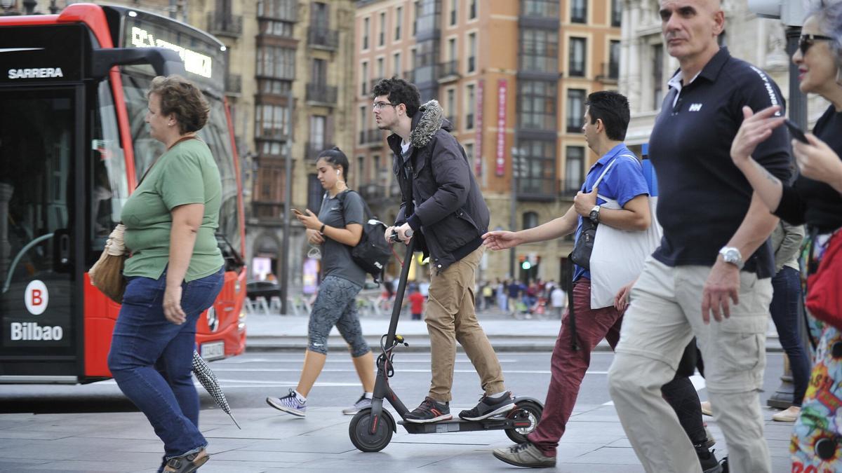Una persona circula con un patinete eléctrico por Bilbao.